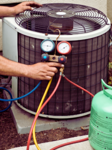 HVAC tech topping up AC unit with freon