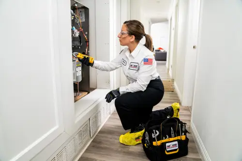 One Hour HVAC tech, Denise, working on the inside of a furnace in a home in Niceville FL