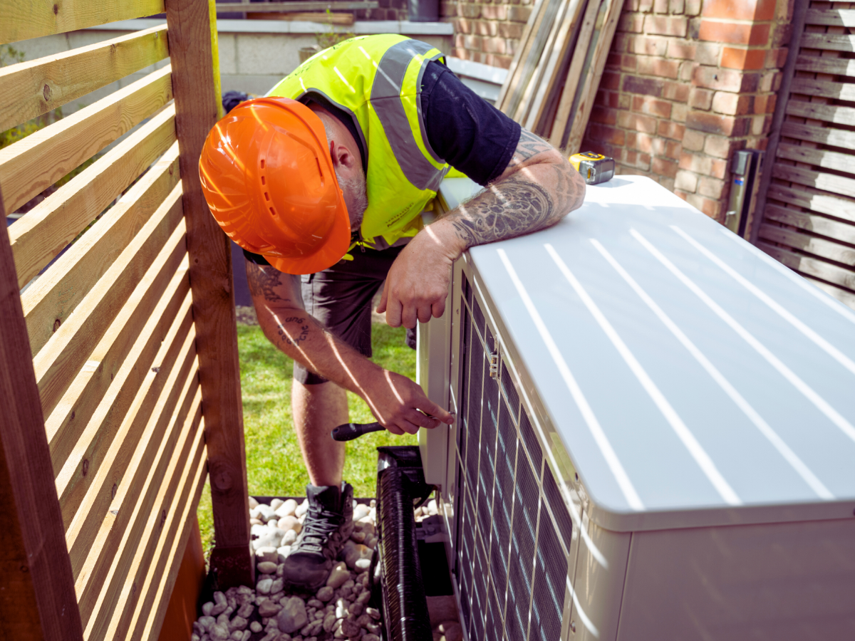 HVAC tech working on outdoor heat pump