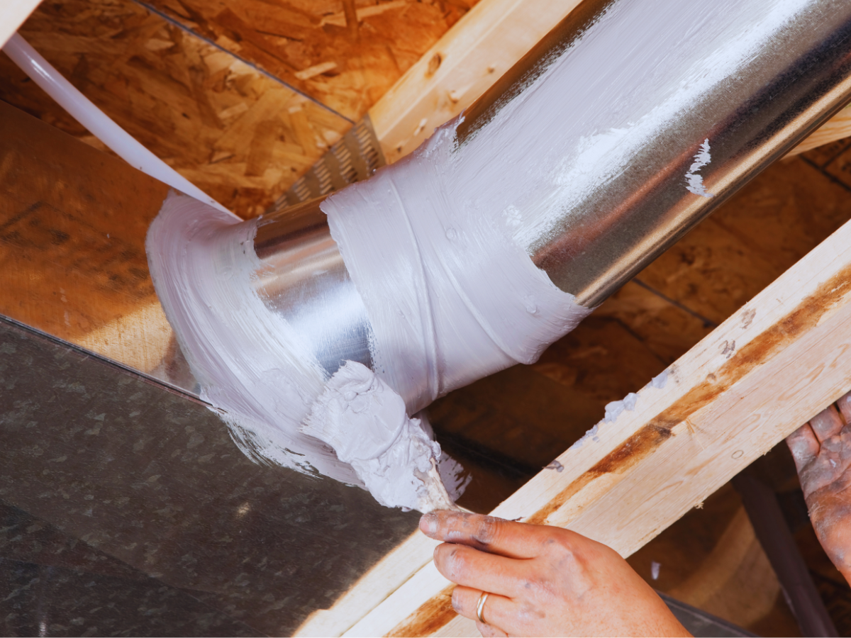 HVAC worker sealing duct joint 