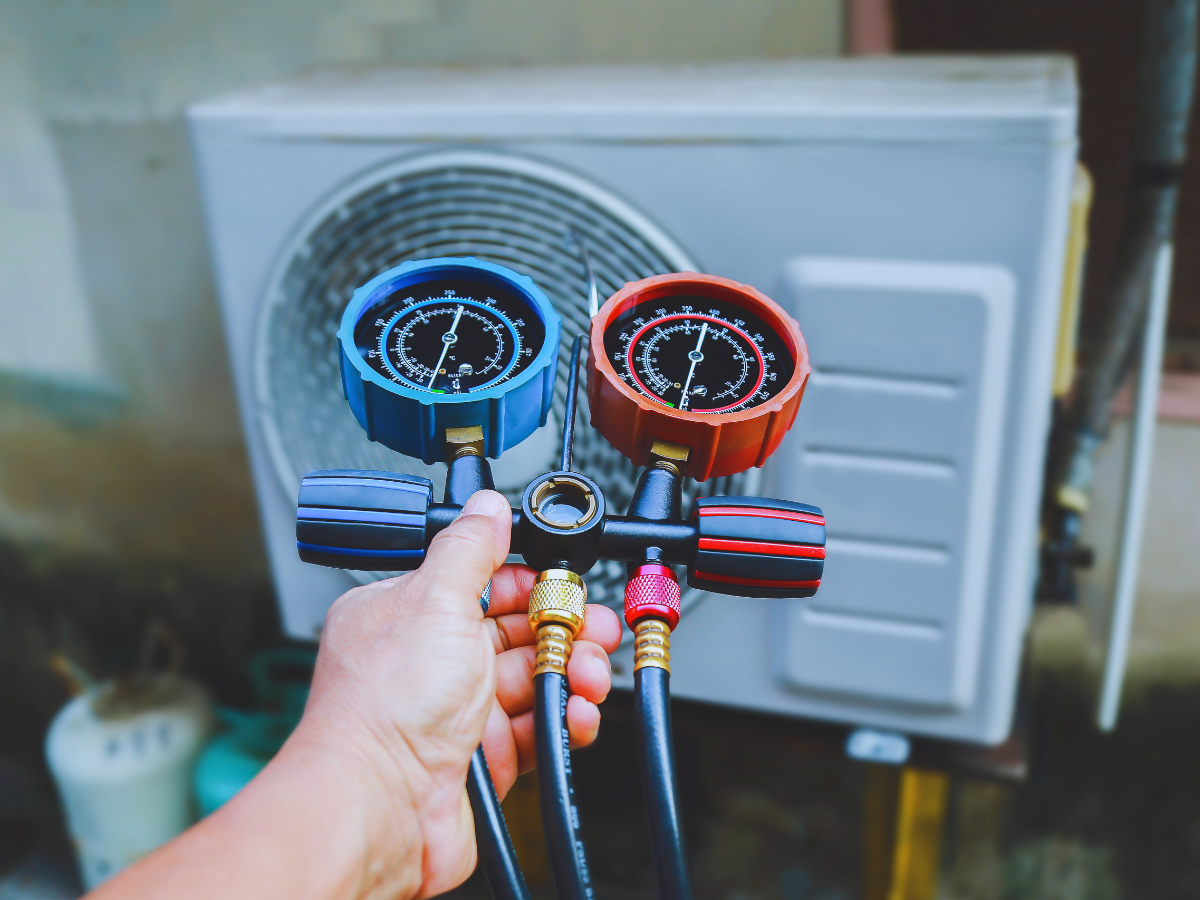 HVAC tech testing refrigerant levels on heat pump